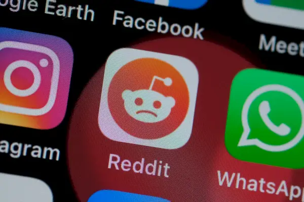 Sur cette photo d'illustration, le logo de Reddit est visible sur l'écran d'un smartphone, mais la petite figure extraterrestre