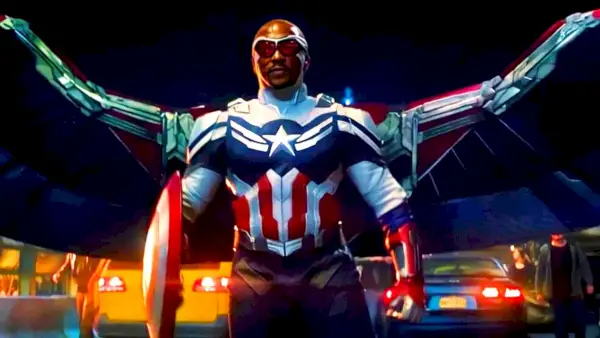 Sam Wilson dans le rôle de Captain America, avec un costume et des ailes à prédominance blanche. Il se tient contre un ciel nocturne.