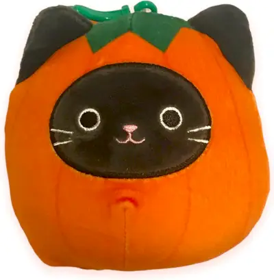 Um gato preto dentro de um squishmallow de abóbora.