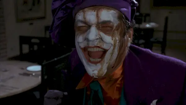 Jack Nicholson riant dans le rôle du Joker dans Batman (1989). Dans un chef violet