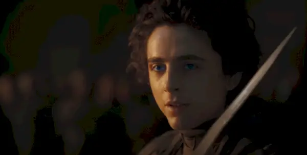 Paul Atreides (Timothee Chalamet) pripravlja svoj nož, medtem ko njegove oči modro žarijo