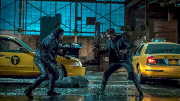 Keanu Reeves într-o scenă de luptă pe o stradă în ploaie în John Wick Capitolul 2.