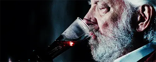 El presidente Snow bebe, dejando sangre en el vaso.