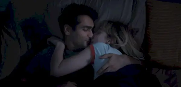 Emily e Kamil se beijam na cama