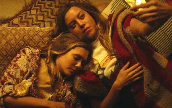 Aubrey Plaza acostada boca arriba con Ashley Olson durmiendo sobre su hombro.