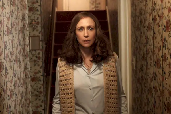 Rudaplaukė balta moteris (Vera Farmiga) žiūri į koridorių