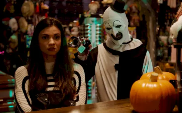 Sienna (Lauren LaVera) og Art the Clown (David Howard Thornton) står ved siden av hverandre i en Halloween-butikk i en scene fra Terrifier 2