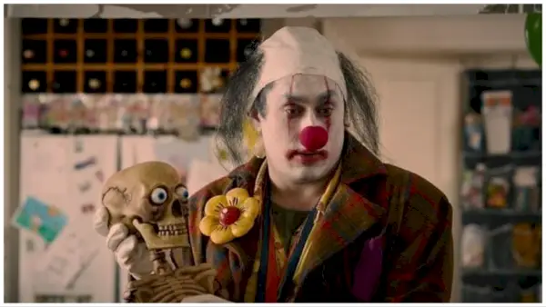 Ross Noble dans le rôle de Stitches, le clown tenant un faux squelette