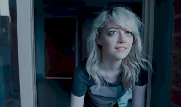 Emma Stone pozerá z okna na oblohu