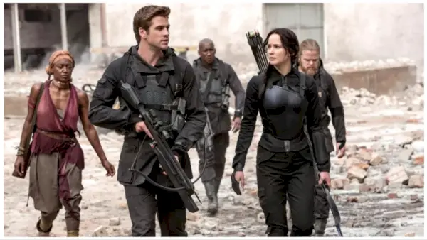 Gale (Liam Hemsworth) ja Katniss (Jennifer Lawrence) tutkivat sodan runtelemaa aluetta kantaen aseita