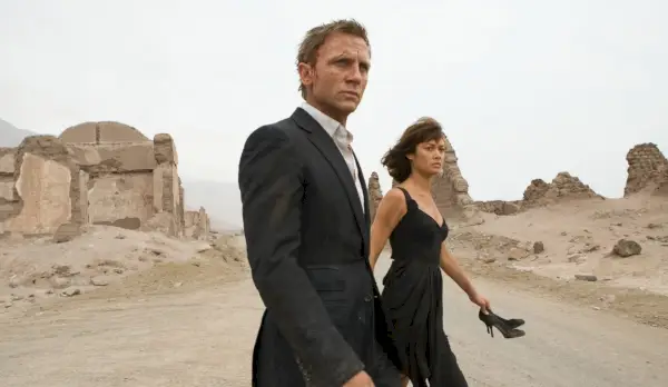 Camille och James går i ett sandigt område i Quantum of Solace