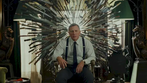 Daniel Craig als Benoit Blanc in Knives Out sitzt auf einem Messerthron