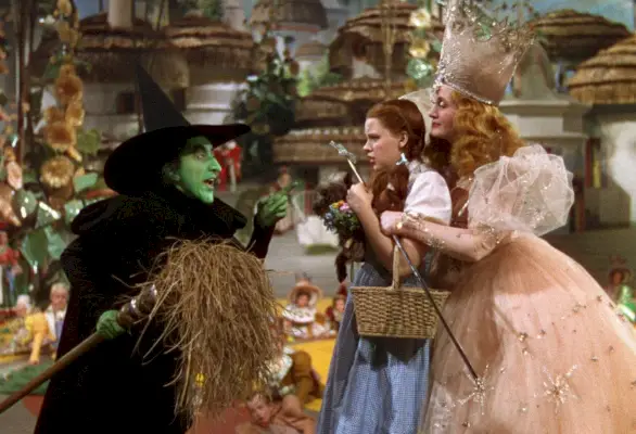 Margaret Hamilton kot Hudobna čarovnica, Judy Garland kot Dorothy in Billie Burke kot Glinda v Čarovniku iz Oza (Warner Bros.)