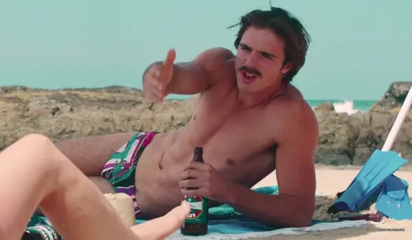 Jacob Elordi in einem Speedo trinkt ein Bier am Strand