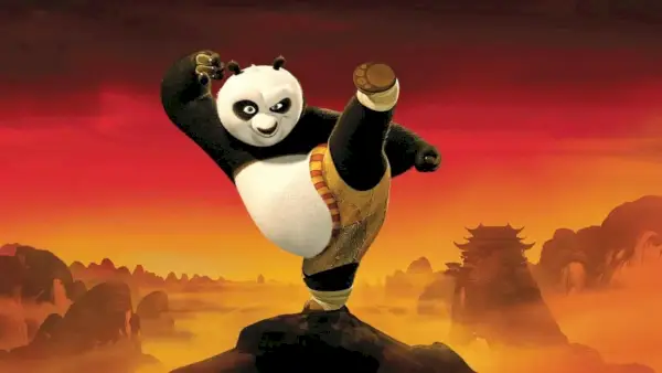 Kung Fu Panda gör en hög spark med en röd solnedgång bakom sig