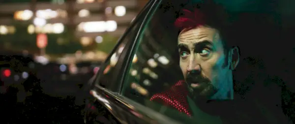 Nicolas Cage olha pela janela de um carro à noite