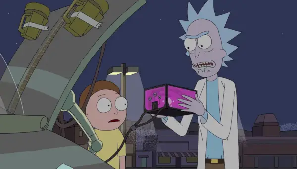 Rick sostiene la batería de un auto en sus manos mientras Morty mira