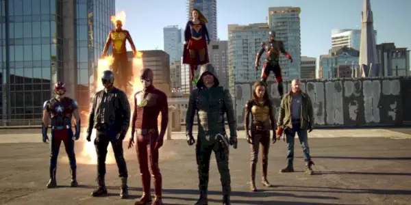 Steel, Spartan, The Flash, Green Arrow, Vixen i Heat Wave stoje u formaciji na zemlji, s Firestormom, Supergirl i Atomom koji lebde iza njih u Invaziji! Arrowverse crossover događaj