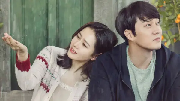 Soo-ah (Son Ye-jin) og Woo-jin (So Ji-sub) sitter ved siden av hverandre i Be With You.