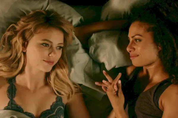 Una mujer llamada Freya Mikaelson (Riley Voelkel) con su prometida Keelin (Christina Moses) tomados de la mano en la cama en The Originals.