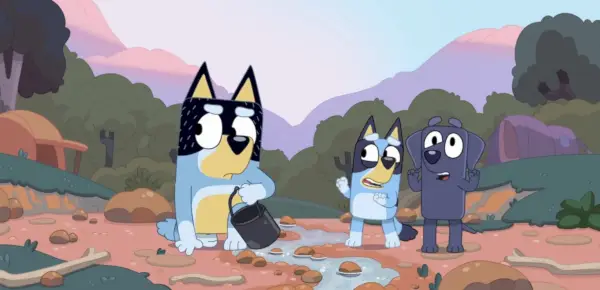 Bandit frunce el ceño mientras Bluey y Jean-Luc miran en el lecho de un arroyo.