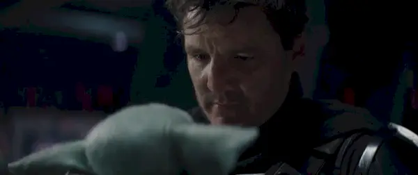 Din Djarin (Pedro Pascal), senza elmo, guardando Grogu