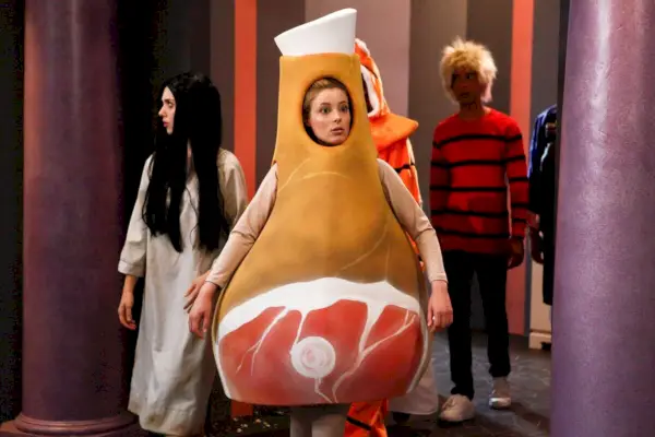 Ainda do episódio Community Paranormal Parentage; Alison Brie como Samara do Ring, em um vestido branco e longa peruca preta, Gillian Jacobs em um terno de osso de presunto e Danny Pudi atrás deles com uma peruca loira desalinhada e top listrado laranja e preto.